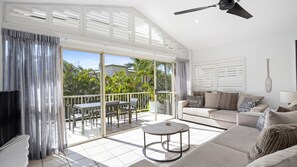 Relax in style with a comfortable seating area, large sliding glass door, and a unique decorative wall.