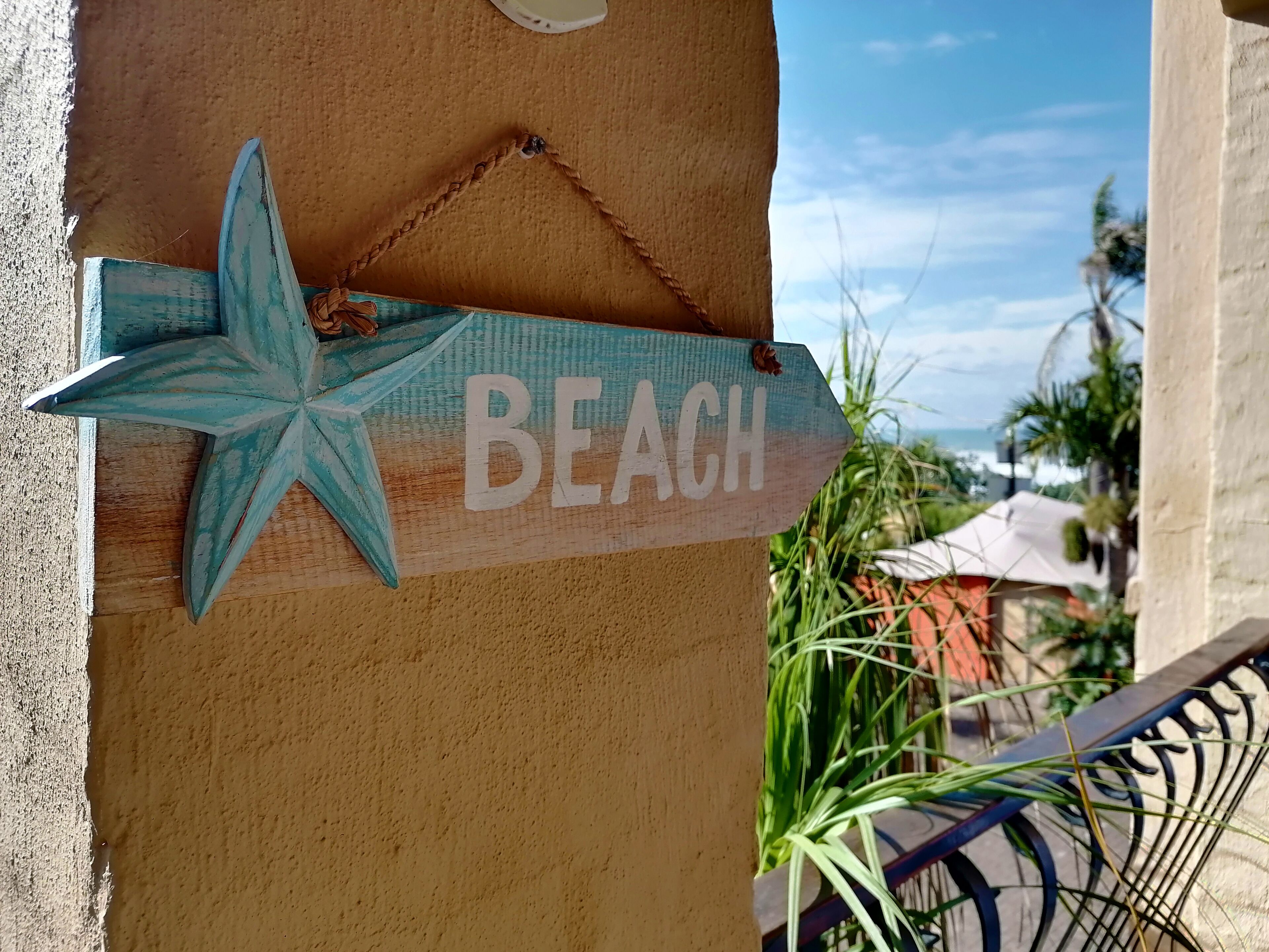 A wooden sign with a star and the word "BEACH" indicating a beachfront location.