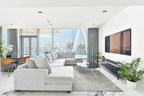 Relax in this stylish living room with a large sofa, flat-screen TV, and city views.