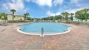 A swimming pool with a brick deck, surrounded by palm trees and a white fence. - Smart home near Disney World, Universal Studios, Silver Spurs Arena (Kissimmee)