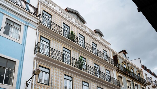 Ein mehrstöckiges Gebäude mit Balkonen, einer gemusterten Fassade und zahlreichen Fenstern.