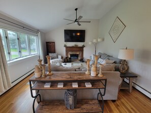 Una sala de estar acogedora con chimenea, un sofá y una mesa de centro con adornos.