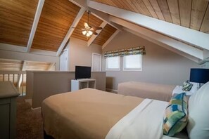 Cozy loft-style bedroom with a large bed, bedside table, and wall-mounted TV.
