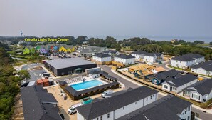 Vista aérea de una zona residencial con casas, una piscina y un edificio grande con el rótulo "COSCO".