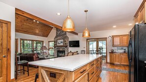 Una cocina amplia con armarios de madera, una isla grande e iluminación colgante.