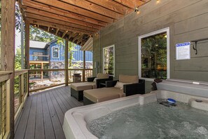 A hot tub area with wooden deck and outdoor seating.