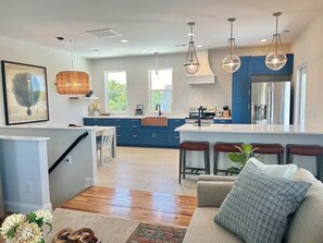 A modern kitchen with blue cabinets, a central island, and pendant lighting. - Boardwalk Beauty - 3 Blocks to Beach - Hot Tub (Carolina Beach)