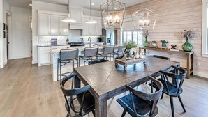 A modern kitchen with white cabinets, a central island with bar stools, and pendant lighting. - Residence Club Unit 6 in Carlton Landing (Carlton Landing)