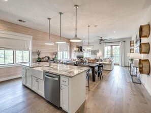 A spacious kitchen with a central island, pendant lights, and a dishwasher. - Residence Club Unit 6 in Carlton Landing (Carlton Landing)