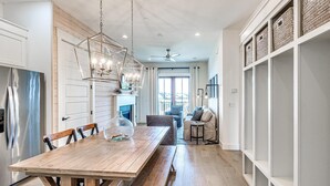 Una cocina amplia con una mesa de comedor de madera, estanterías empotradas y una lámpara colgante moderna.