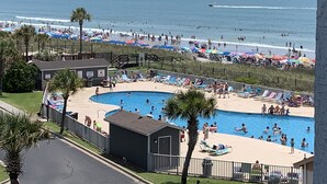 Ein Poolbereich mit Blick auf Strand und Meer.