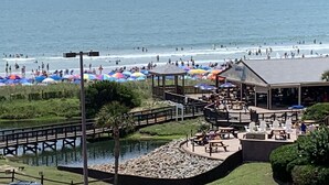 Ein Strandresort mit einer Pier, einem Poolbereich und Strandstühlen.