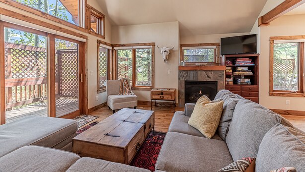 A spacious living room with a fireplace, large windows, and a cozy seating area. - Mountain Escape at Paloverde – Spacious 4-Bedroom Retreat with Private Hot Tub! (Steamboat Springs)