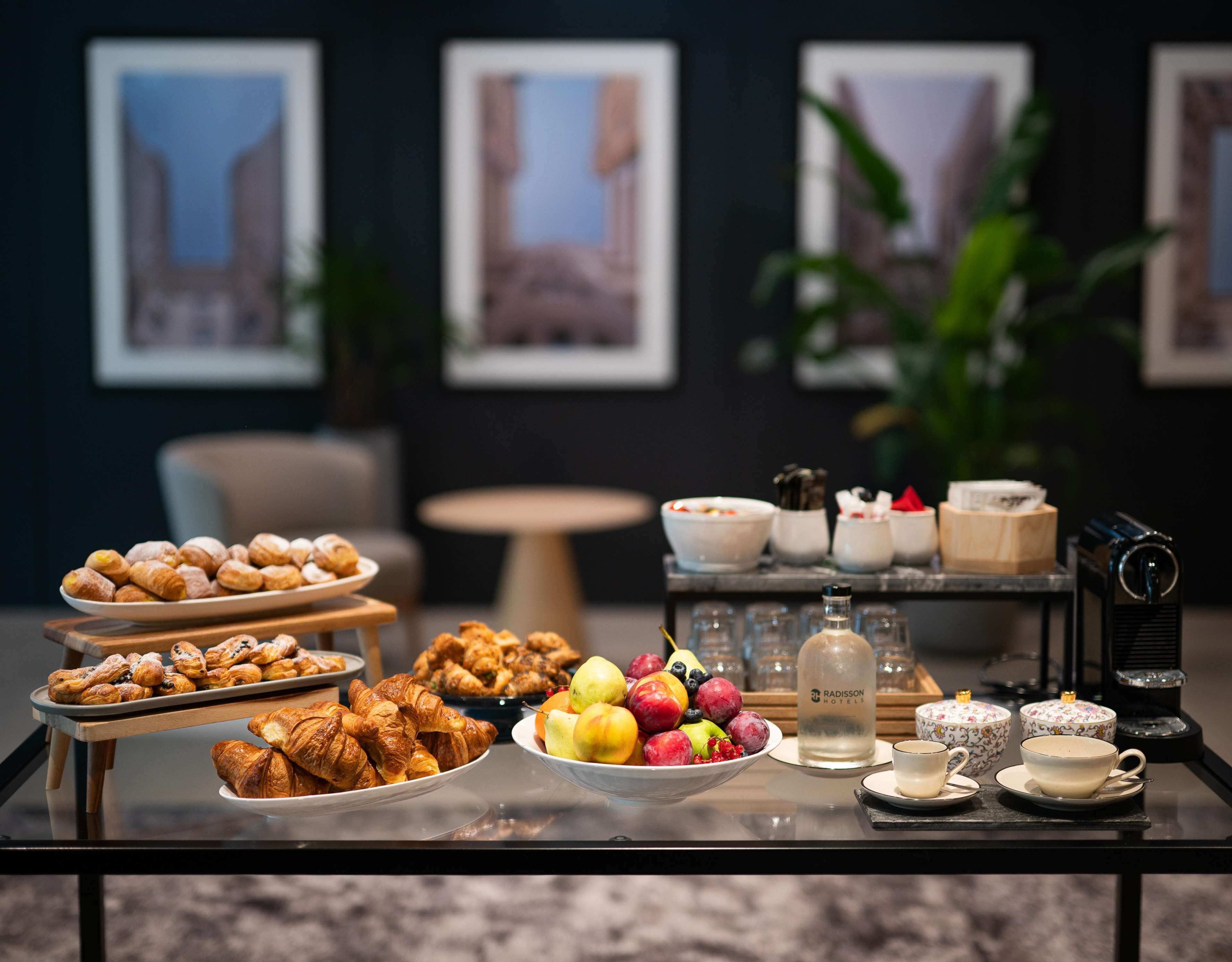 A buffet table with pastries, fruits, and beverages.