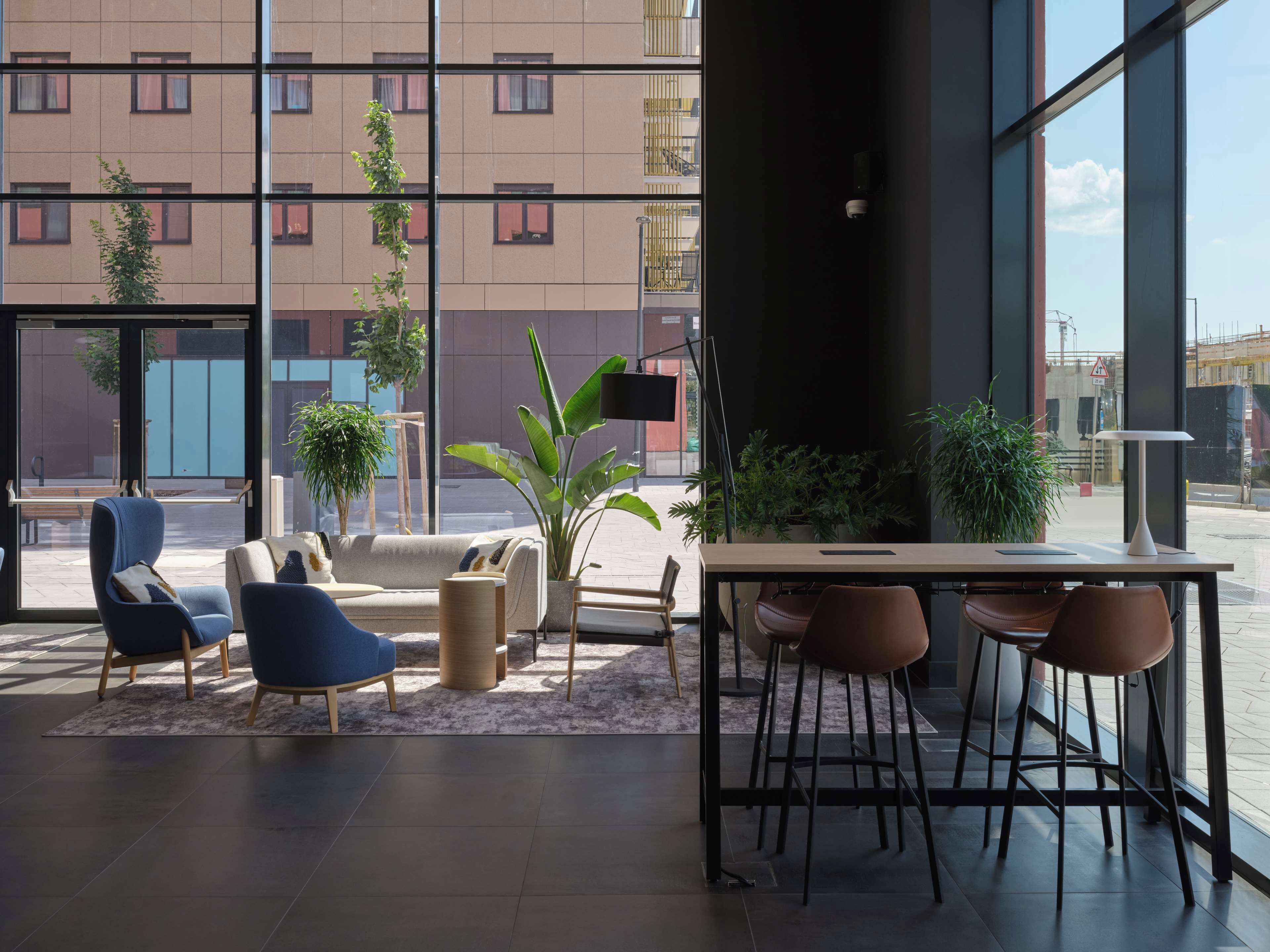 A modern interior with a seating area, a table, and potted plants.