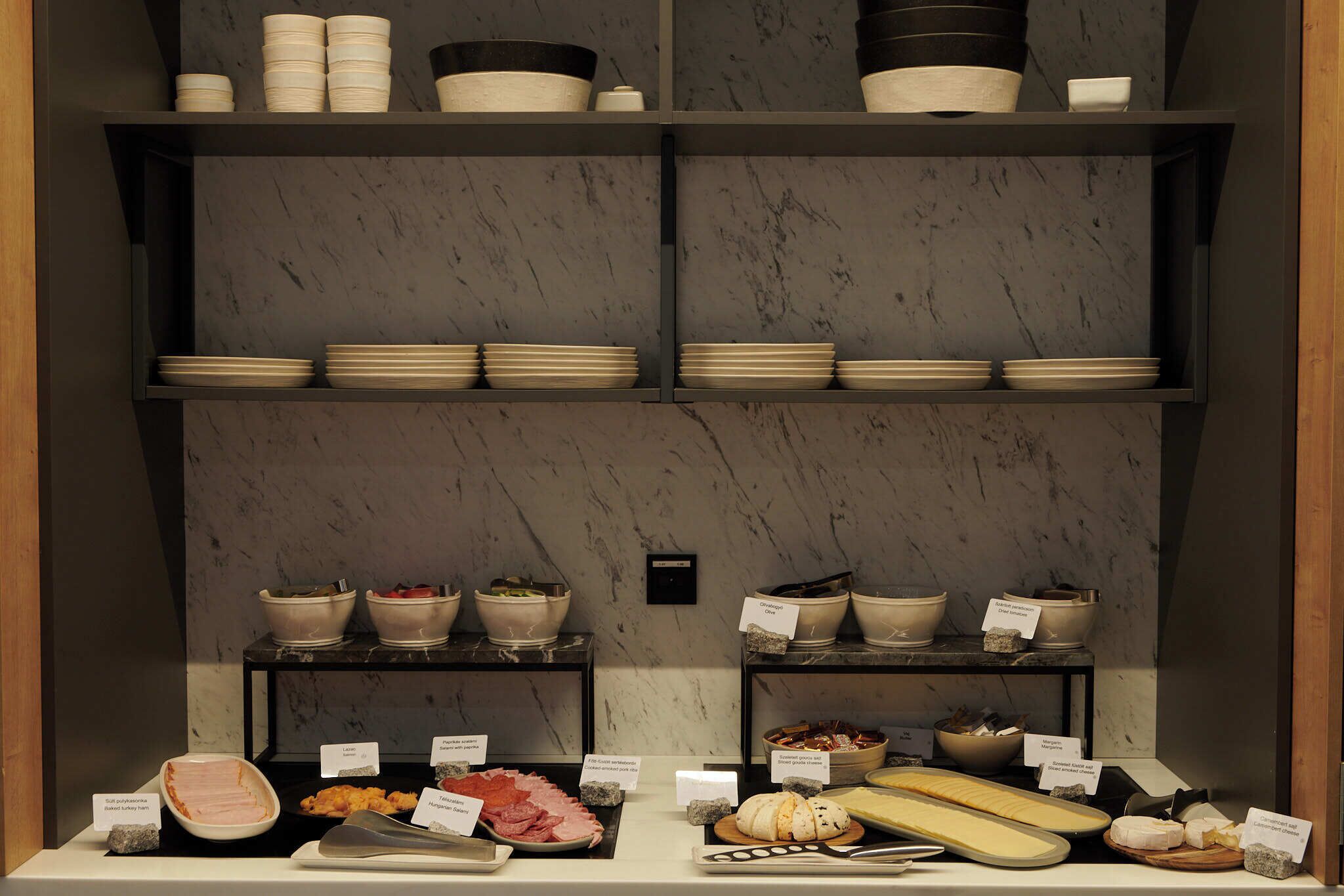 A buffet setup with various food items and dishes on display.