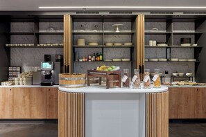 A modern kitchen area with marble shelves, a coffee machine, and various kitchen utensils. - Radisson Hotel Budapest Budapart (Budapest)