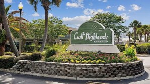 A sign for Gulf Highlands Beach Resort surrounded by landscaped gardens and palm trees. - Paradise Pointe 137–5 Min to Beach–Sleeps 6 (Panama City Beach)