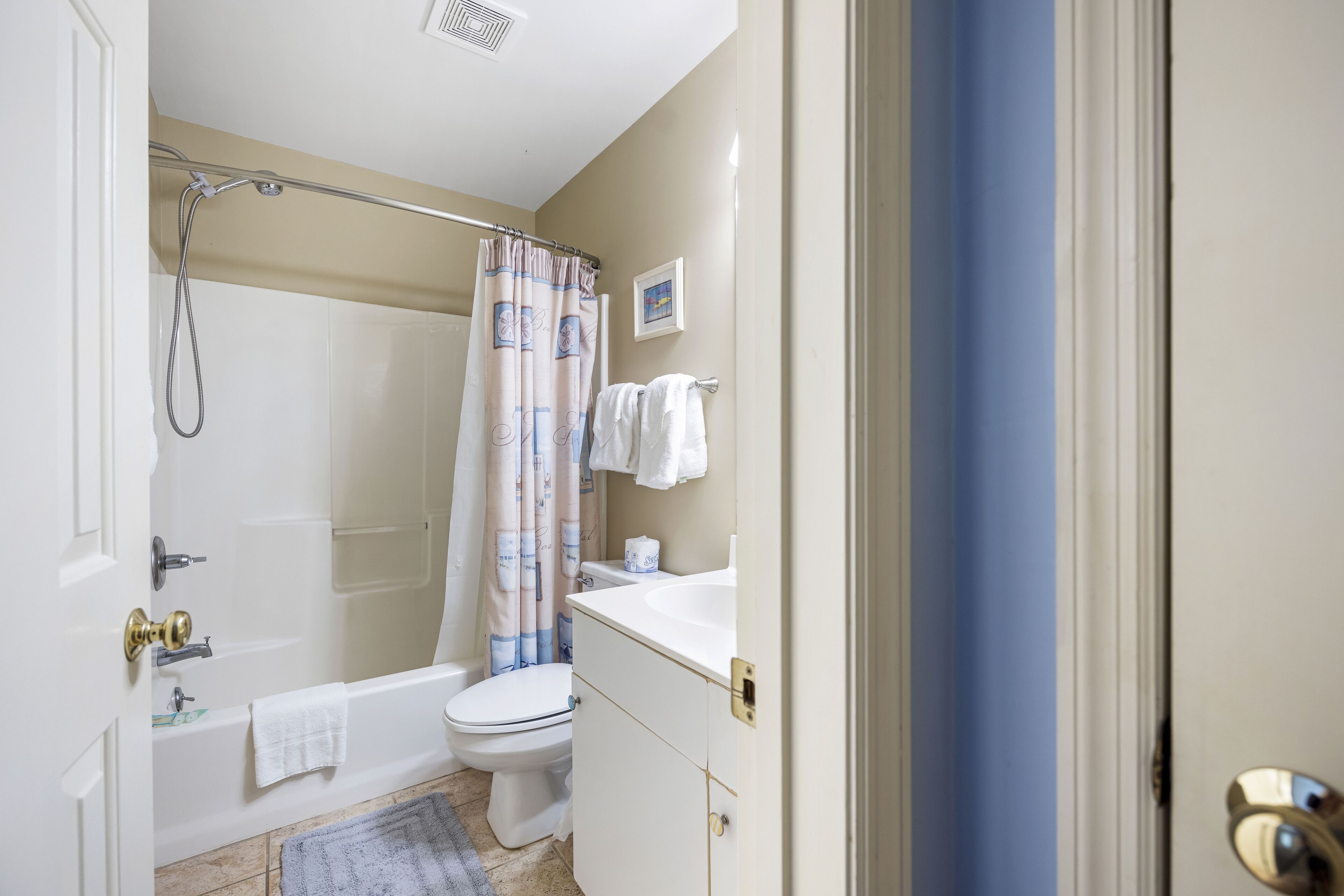 A bathroom with a bathtub, toilet, and shower curtain.
