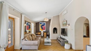 A living room with a sofa, coffee table, TV, and a fireplace.
