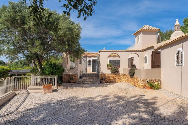 A building with a cobblestone courtyard, stone walls, and arched doorways.