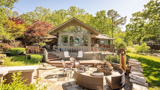 A house with a large deck, outdoor seating, and a fire pit. - Greers Ferry Lakefront Home in Eden Isle (Heber Springs)