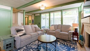 A living room with two sofas, a coffee table, and a fireplace.