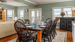 A dining area with a wooden table set for four, surrounded by black chairs. - These are the Days - Gulf Beachfront, 5 Bedroom, 3 Full/3 Half Baths, Sleeps 15 (Dauphin Island)