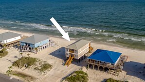 A beachfront property with multiple buildings, including a large house with a blue roof and a smaller structure with a grey roof. - These are the Days - Gulf Beachfront, 5 Bedroom, 3 Full/3 Half Baths, Sleeps 15 (Dauphin Island)