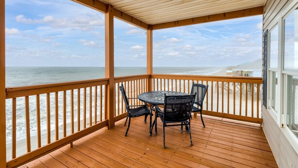 A wooden deck with a table and chairs, overlooking a beach and ocean. - These are the Days - Gulf Beachfront, 5 Bedroom, 3 Full/3 Half Baths, Sleeps 15 (Dauphin Island)