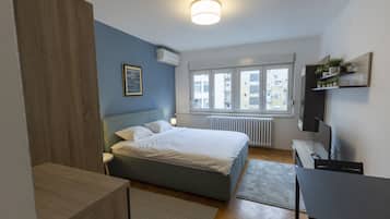Un dormitorio moderno con cama, mesita de noche y televisor.