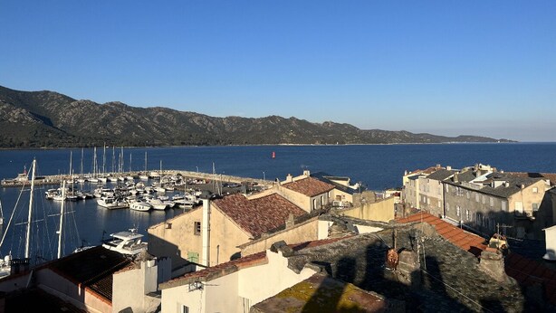 A coastal town with a marina, historic buildings, and a clear blue sky. - Appartement Neuf 83m² vue Mer, Pleins Coeur de St Florent (Saint-Florent)
