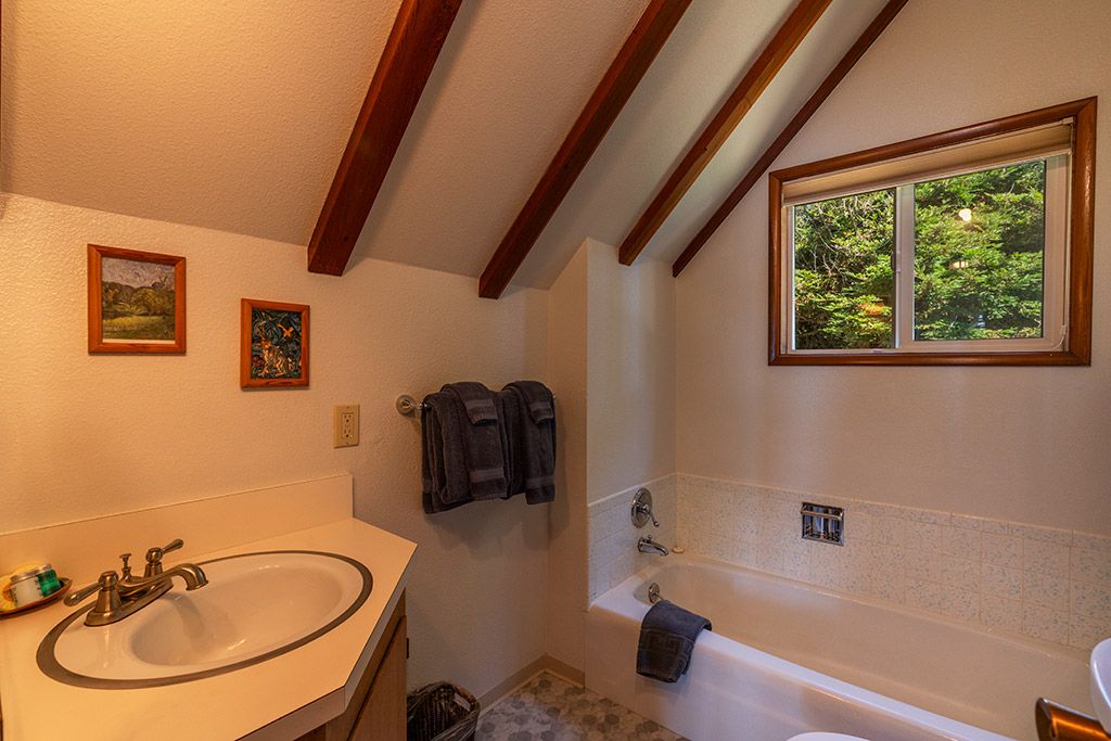 Un baño con lavamanos, bañera y ventana.