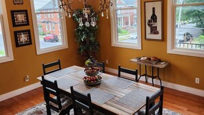 Comedor con una araña, un árbol de Navidad y una mesa dispuesta para seis comensales.