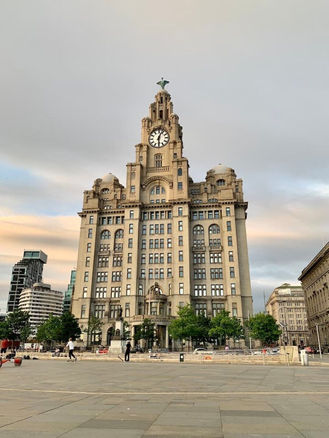 Un edificio grande e histórico con una imponente torre de reloj, múltiples ventanas y una cúpula central.