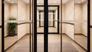 A modern elevator with glass doors and a potted plant beside it. - Luxury just 10 minutes from central Paris. Free Parking (Vitry-sur-Seine)