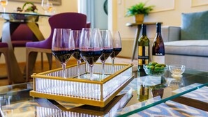 Una mesa de comedor con una bandeja que contiene copas de vino, una botella de vino y un cuenco de aceitunas.
