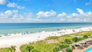 A beach with white sand, clear blue water, and a few umbrellas. - Sunset views over the Gulf.  Beachside BEST.  The perfect getaway for two!   (Panama City Beach)