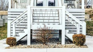 A two-story house with a porch, a sign that reads "Jivefly," and a staircase leading to the entrance.