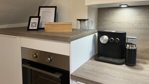 Eine moderne Küche mit integrierter Espressomaschine, Kaffeemaschine und einer gerahmten Speisekarte.