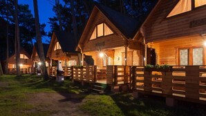 Une rangée de cabanes en bois, dotées d’un porche abrité et d’une enseigne bien visible.