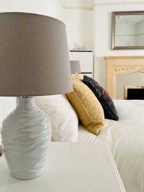 Relax in a serene space with a comfortable bed, elegant headboard, and soft lighting.