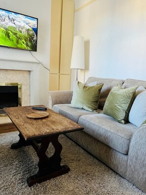Relax in this stylish living room with a comfortable sofa, coffee table, and flat-screen TV.
