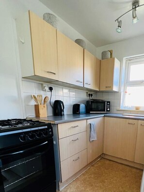 Enjoy cooking in this well-equipped kitchen with a gas stove, microwave, and toaster, and take in the view from the window.