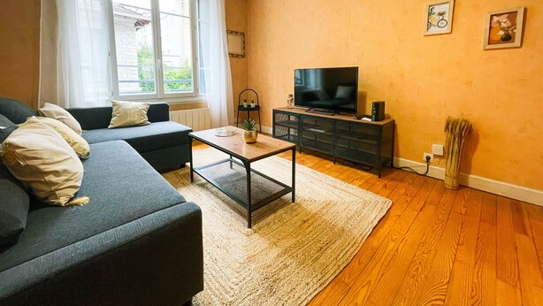 A living room with a sofa, coffee table, TV, and a small plant. - #FL | The Harmony of Eras 🕊️ - T2 - Calm (Grenoble)