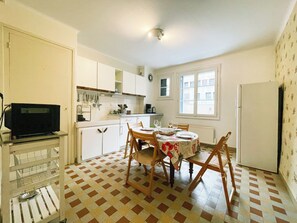 Enjoy meals in the kitchen with a dining area featuring a round table and comfortable chairs.