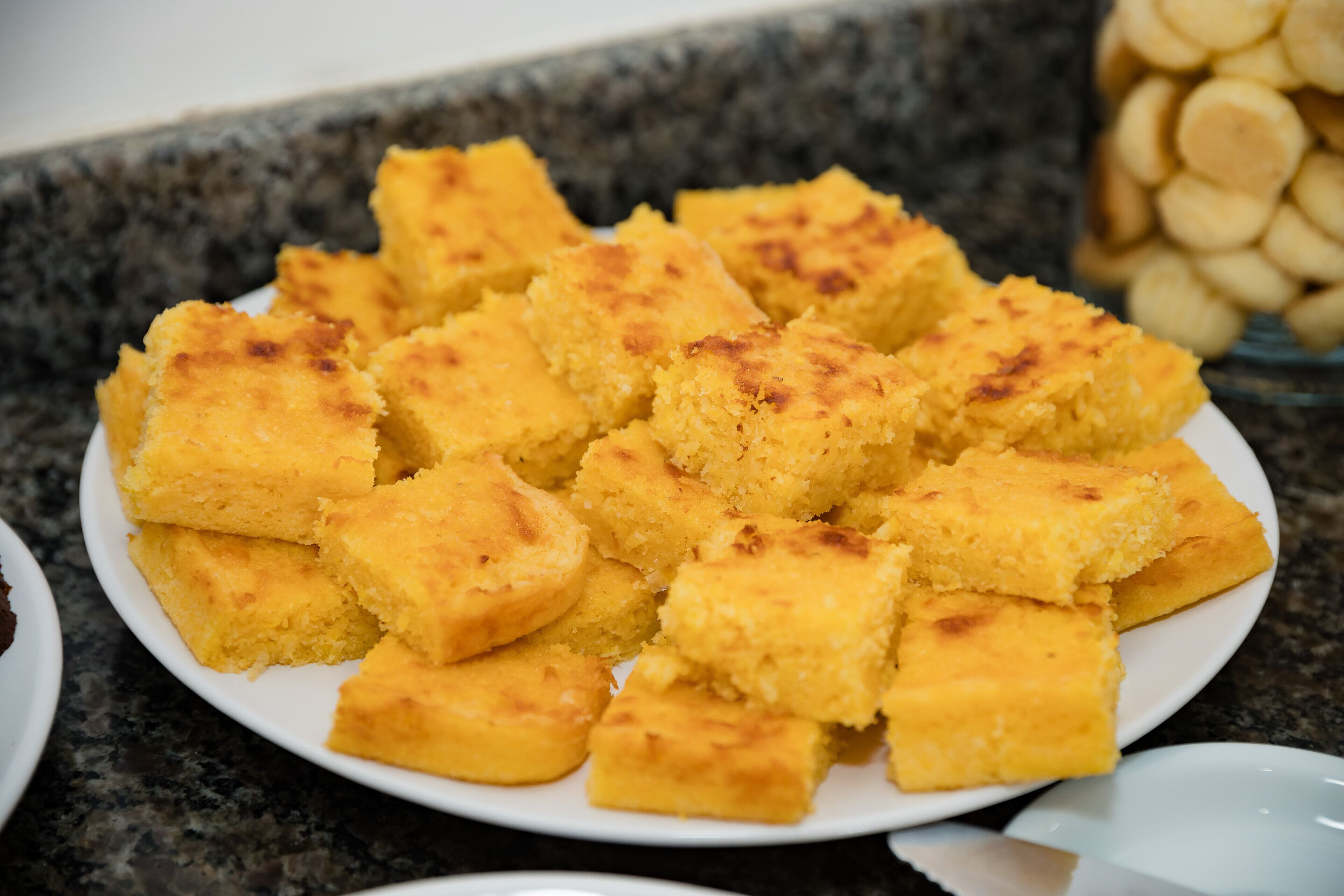 Un plato de cuadrados de pan de maíz sobre una encimera de granito.