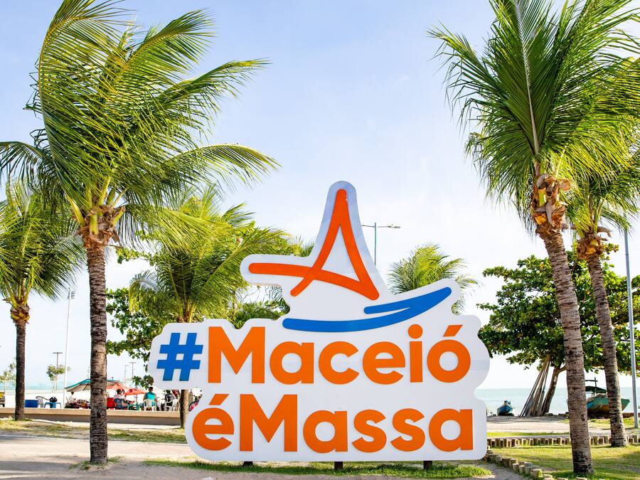 Une affiche avec le texte « #Maceió éMassa » et un « A » stylisé intégrant un motif ondulé.