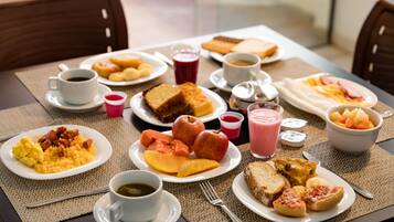 Um buffet de café da manhã com diversos pratos e bebidas.