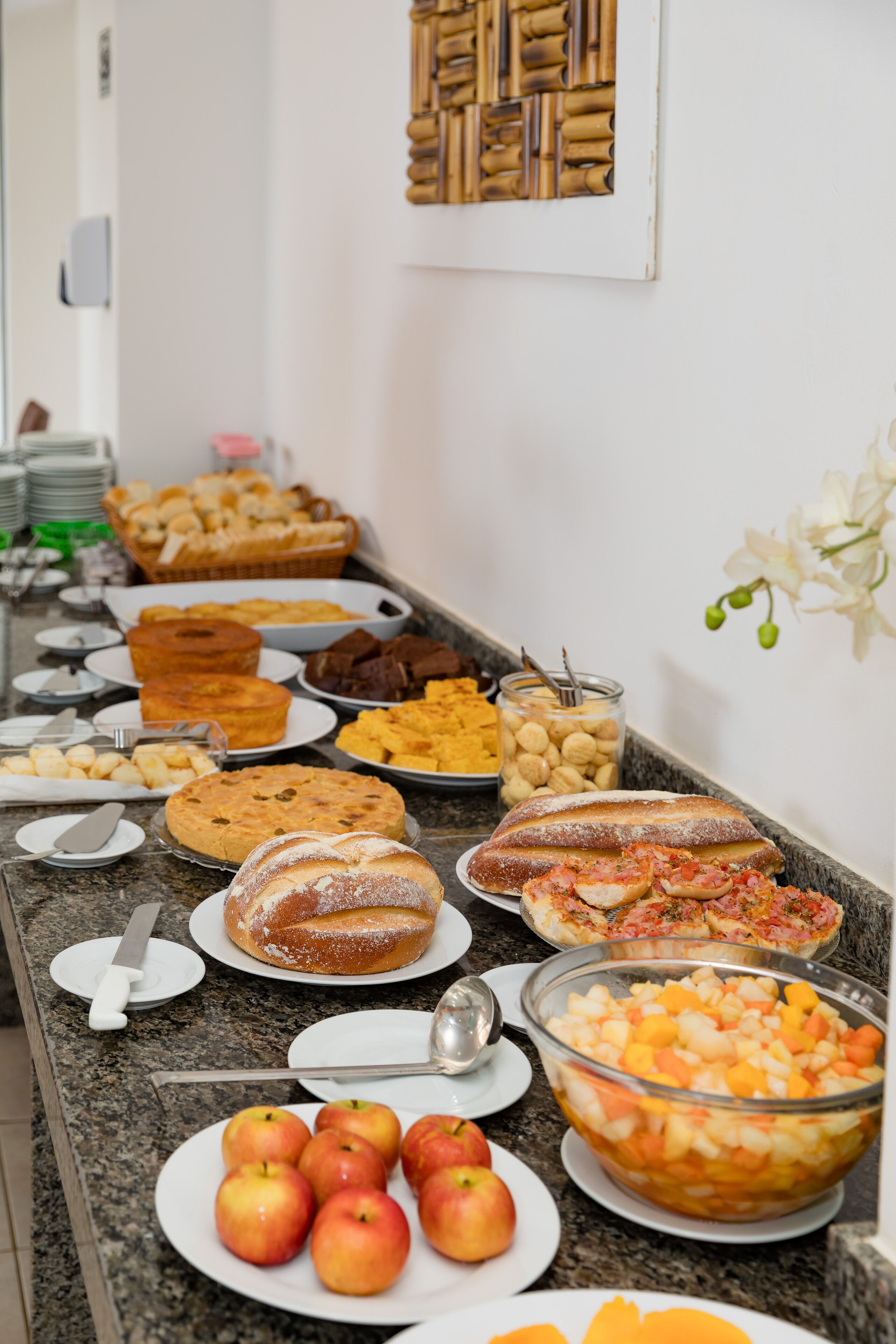 A buffet with various food items including fruits, pastries, and desserts.